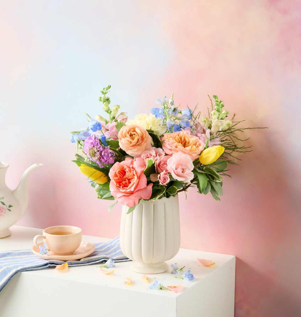 Spring flower arrangement in a vase on a table, blurred background