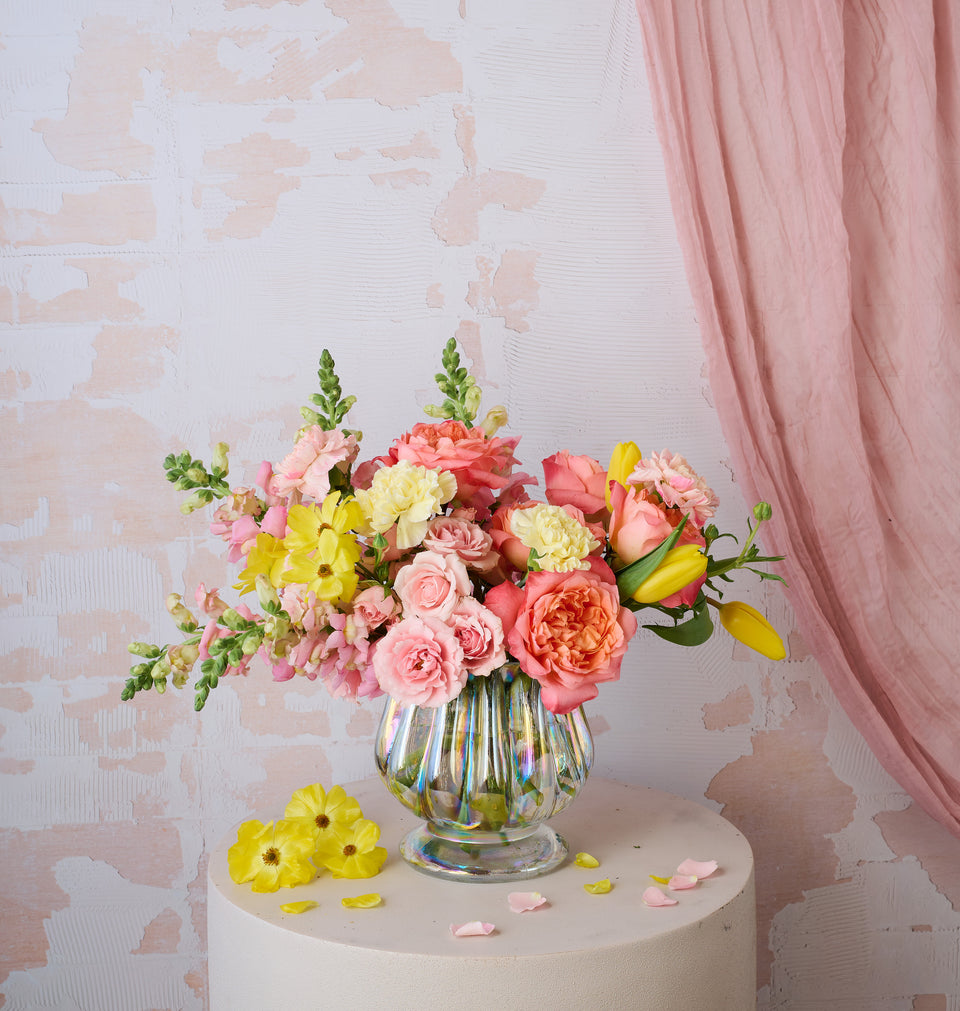 Sunburst bouquet with vibrant warm-toned flowers in a vase